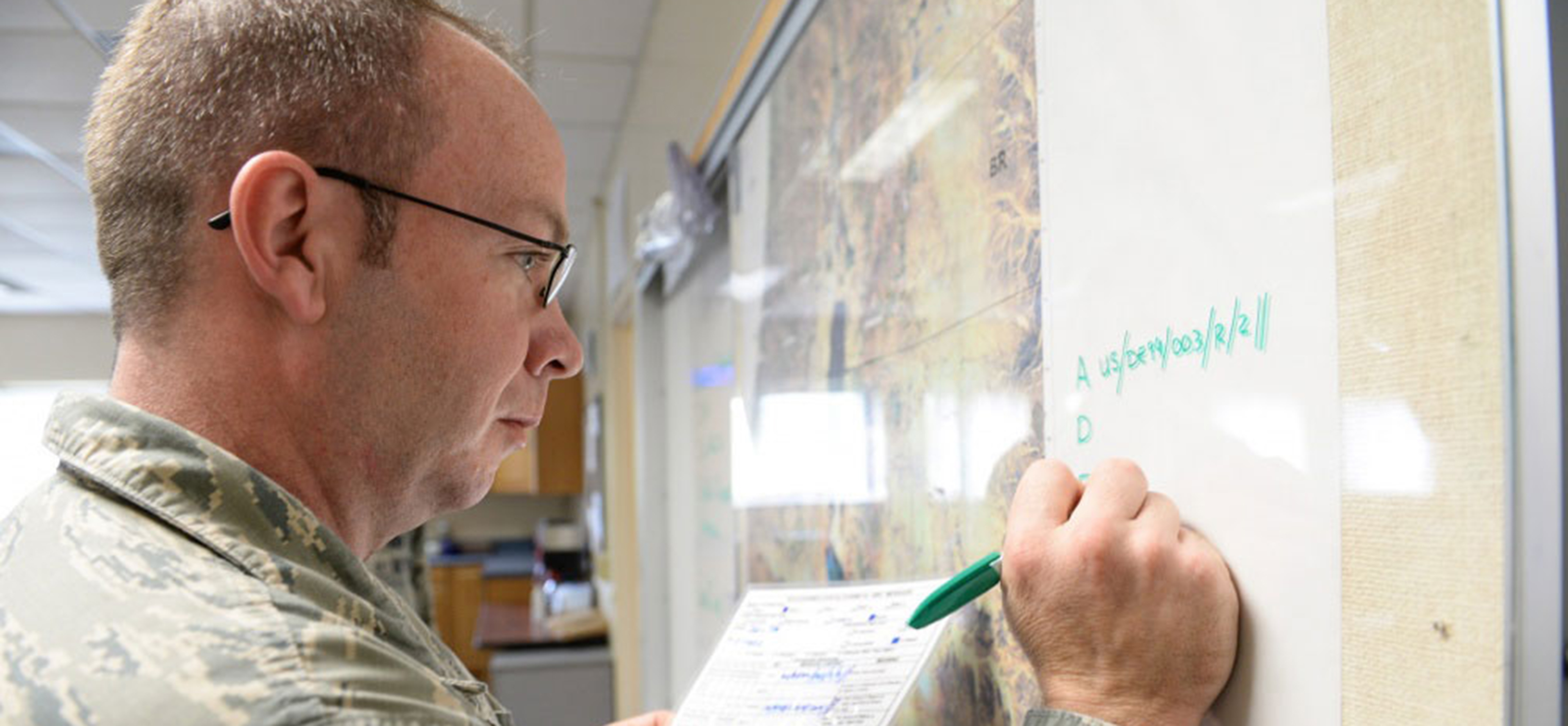 Military student writing on whiteboard